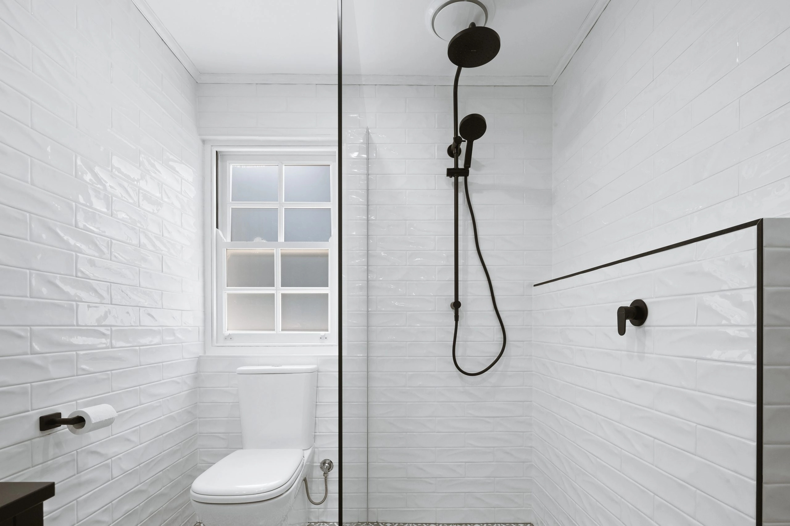White subway tiled bathroom with black accessories