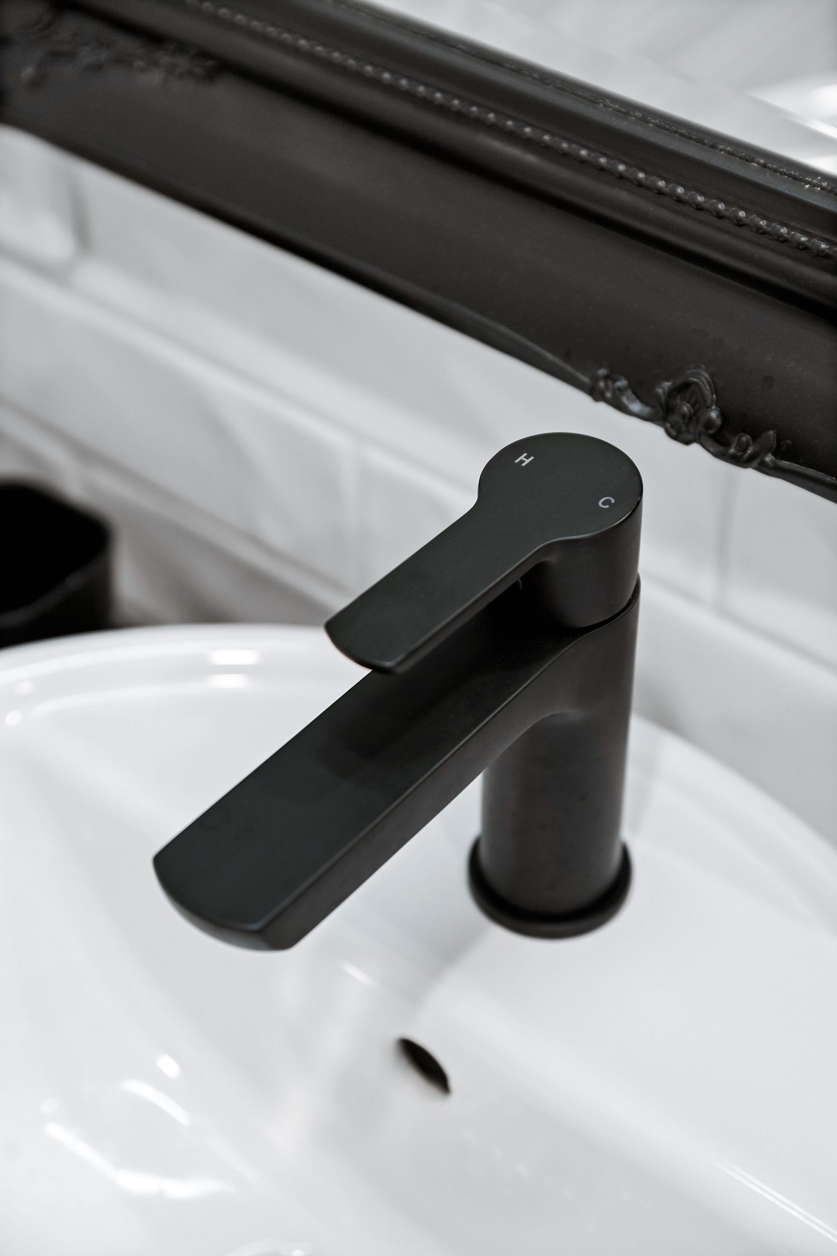 Close up of a matte black tap on a white bathroom sink