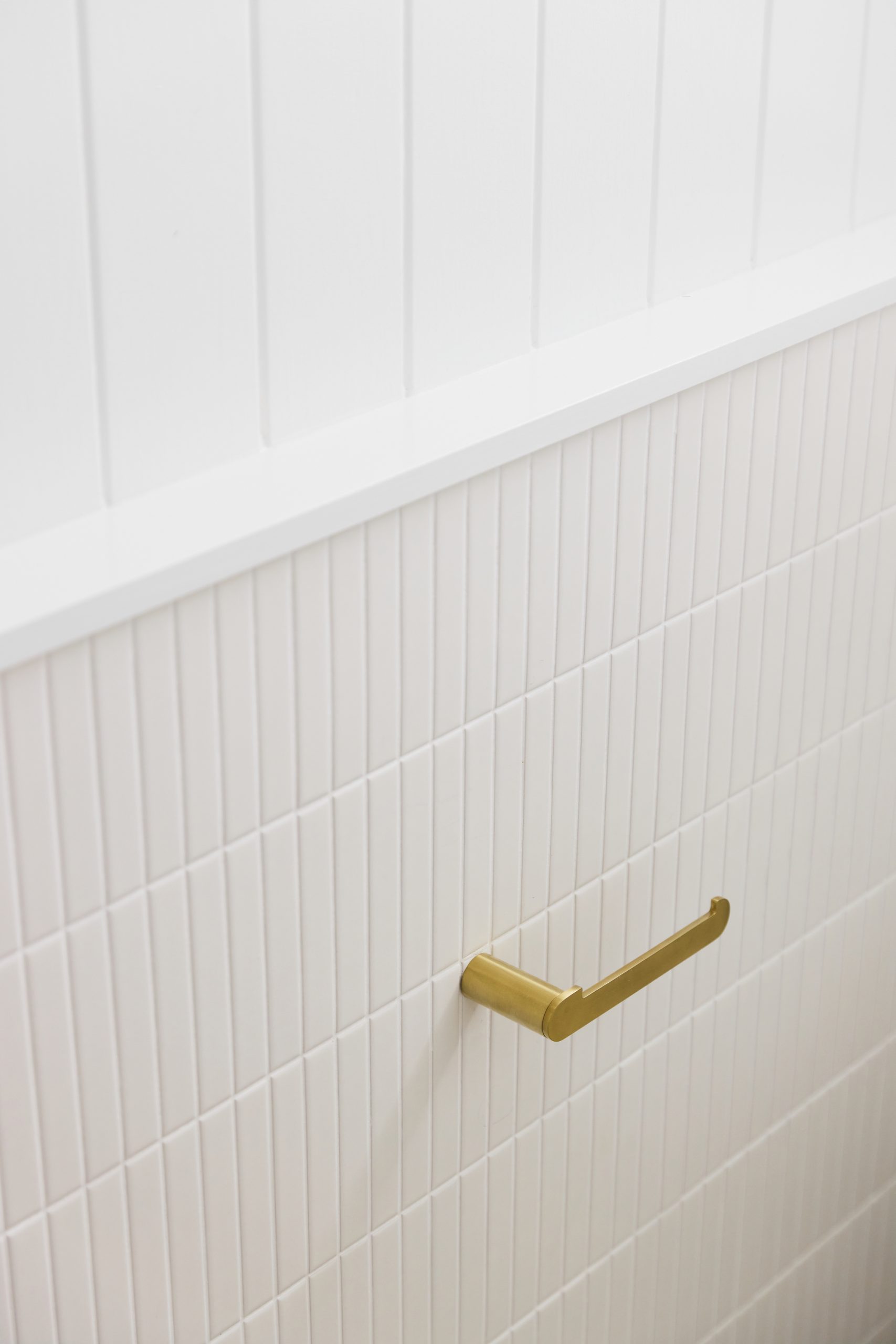 Gold handle on light bathroom tiles