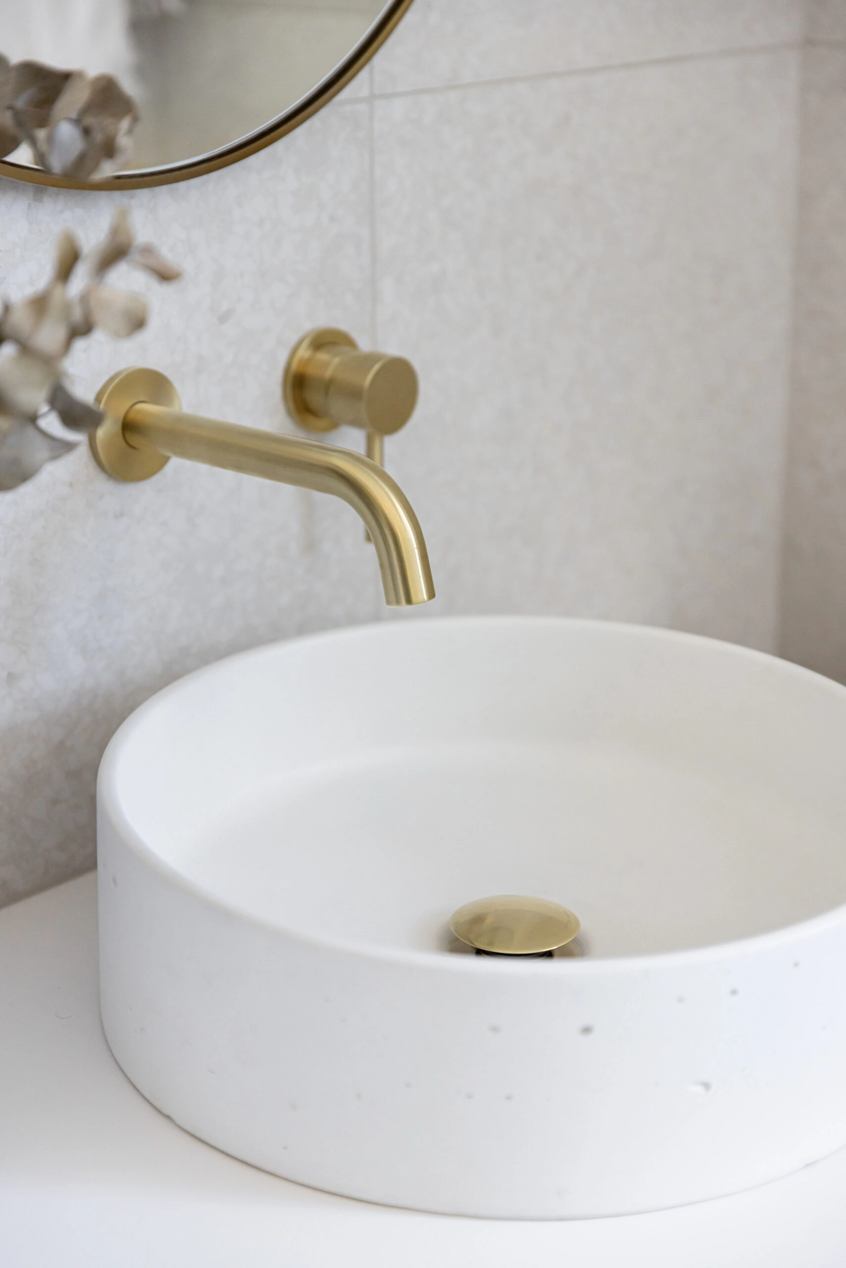 White and gold sink in a bathroom renovation photo.