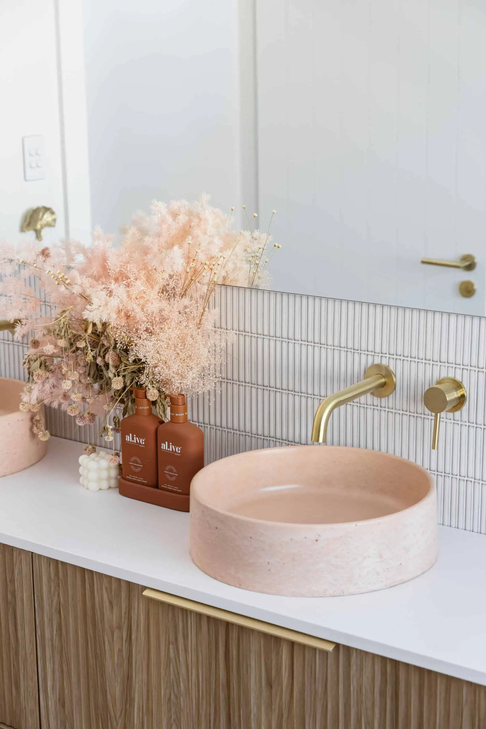 Blush pink sinks on a modern bathroom vanity in a renovation after shot.