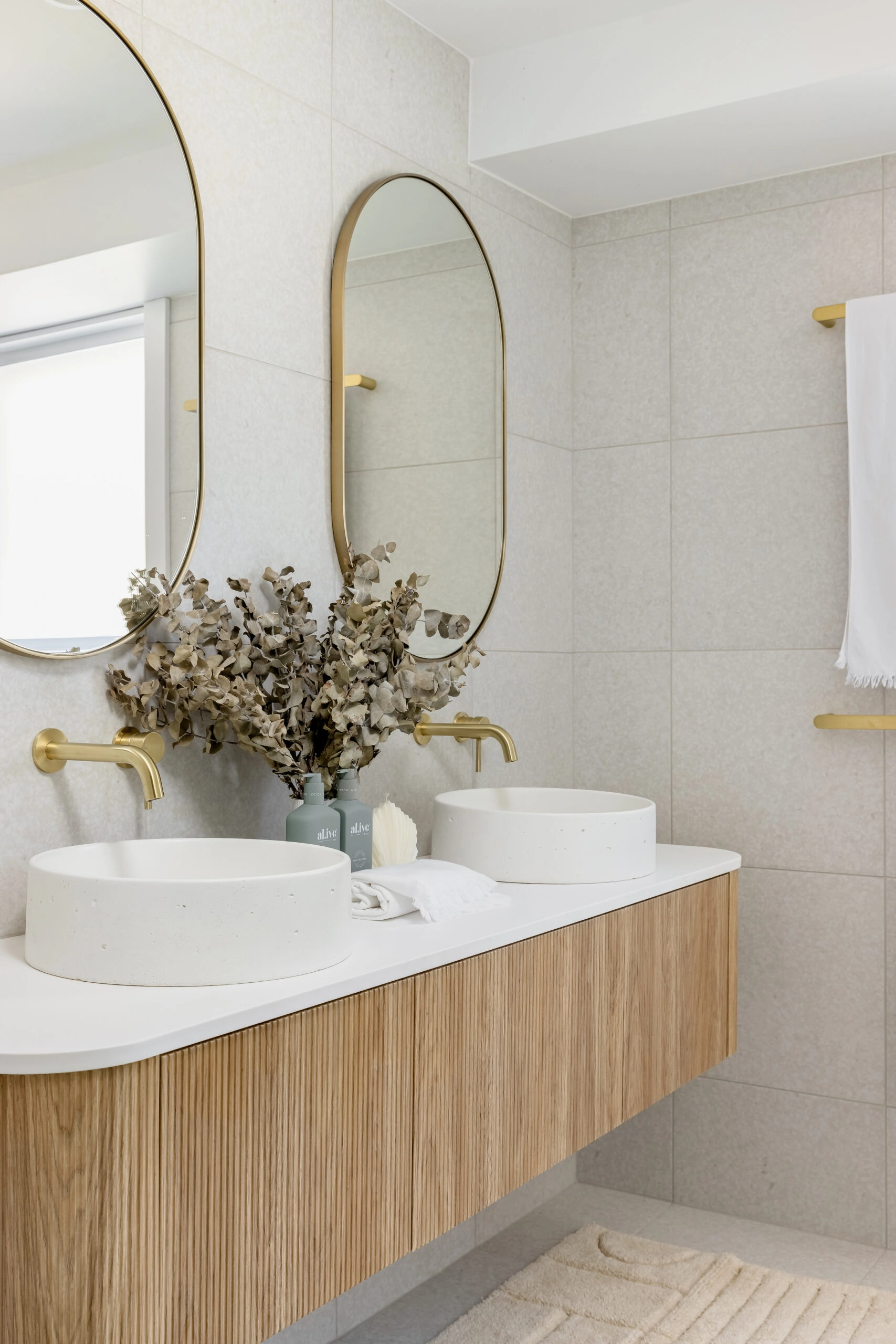 After photograph of a modern bathroom vanity with gold accents.