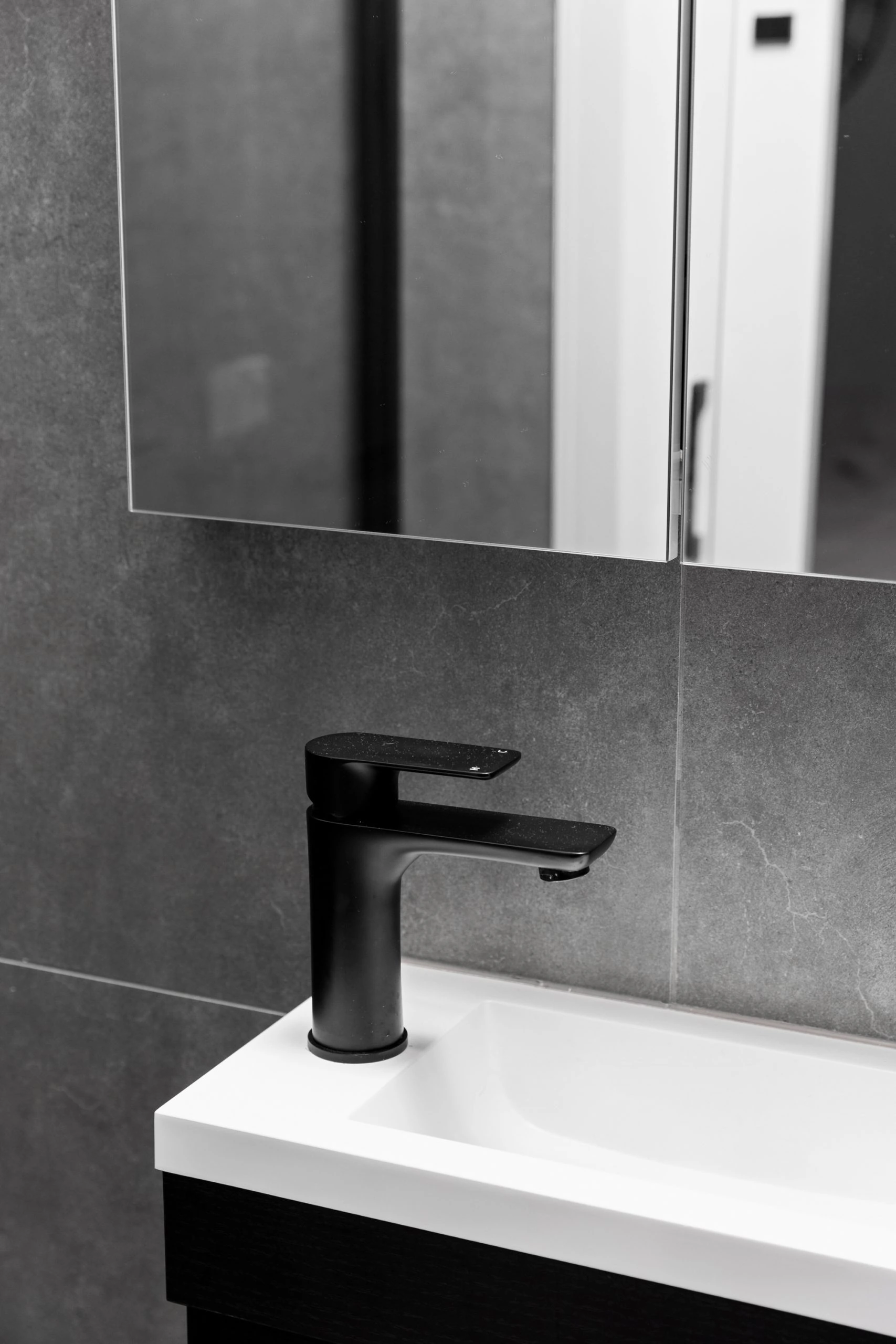 Matte black tap in a dark grey and white bathroom