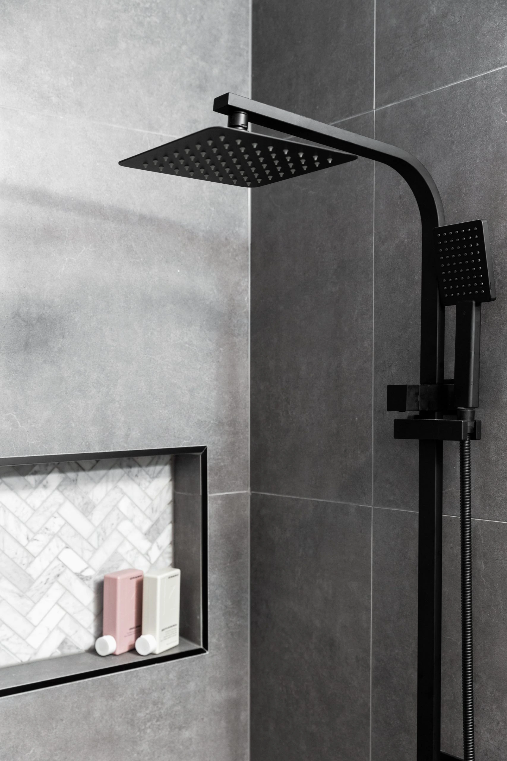 Dark grey bathroom featuring shower unit and wall niche