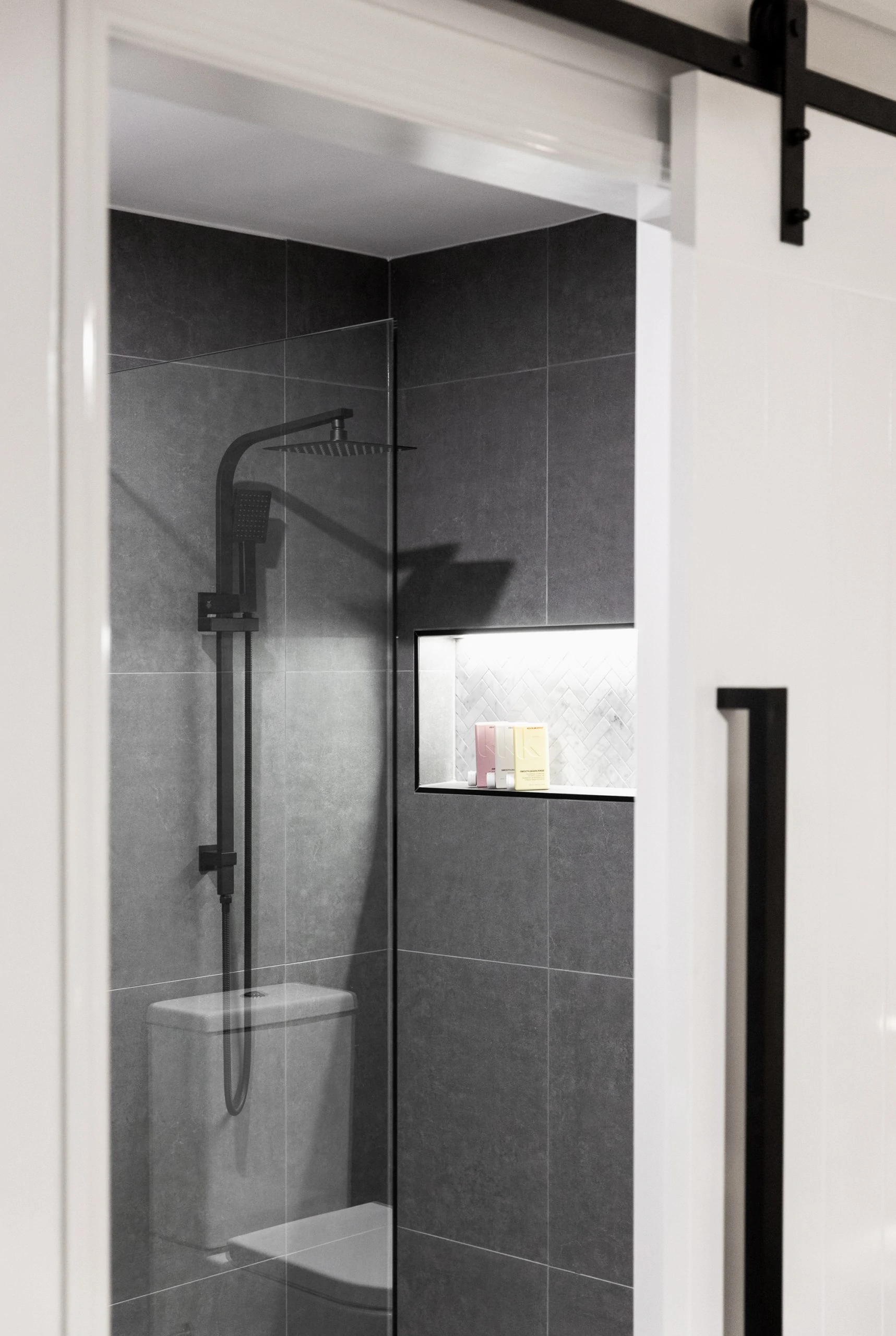 Door open to reveal a modern dark grey bathroom