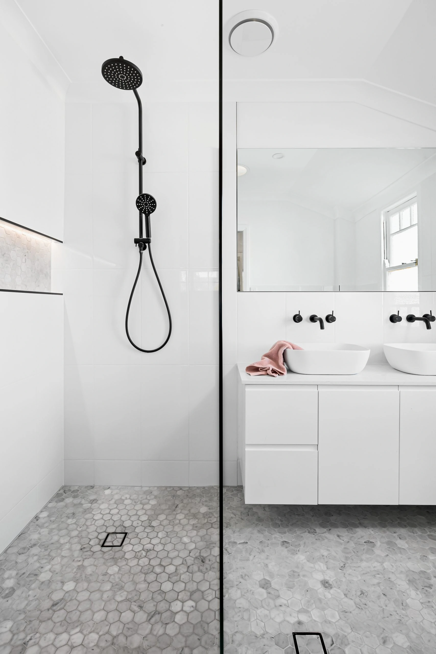White bathroom with large mirror and black details