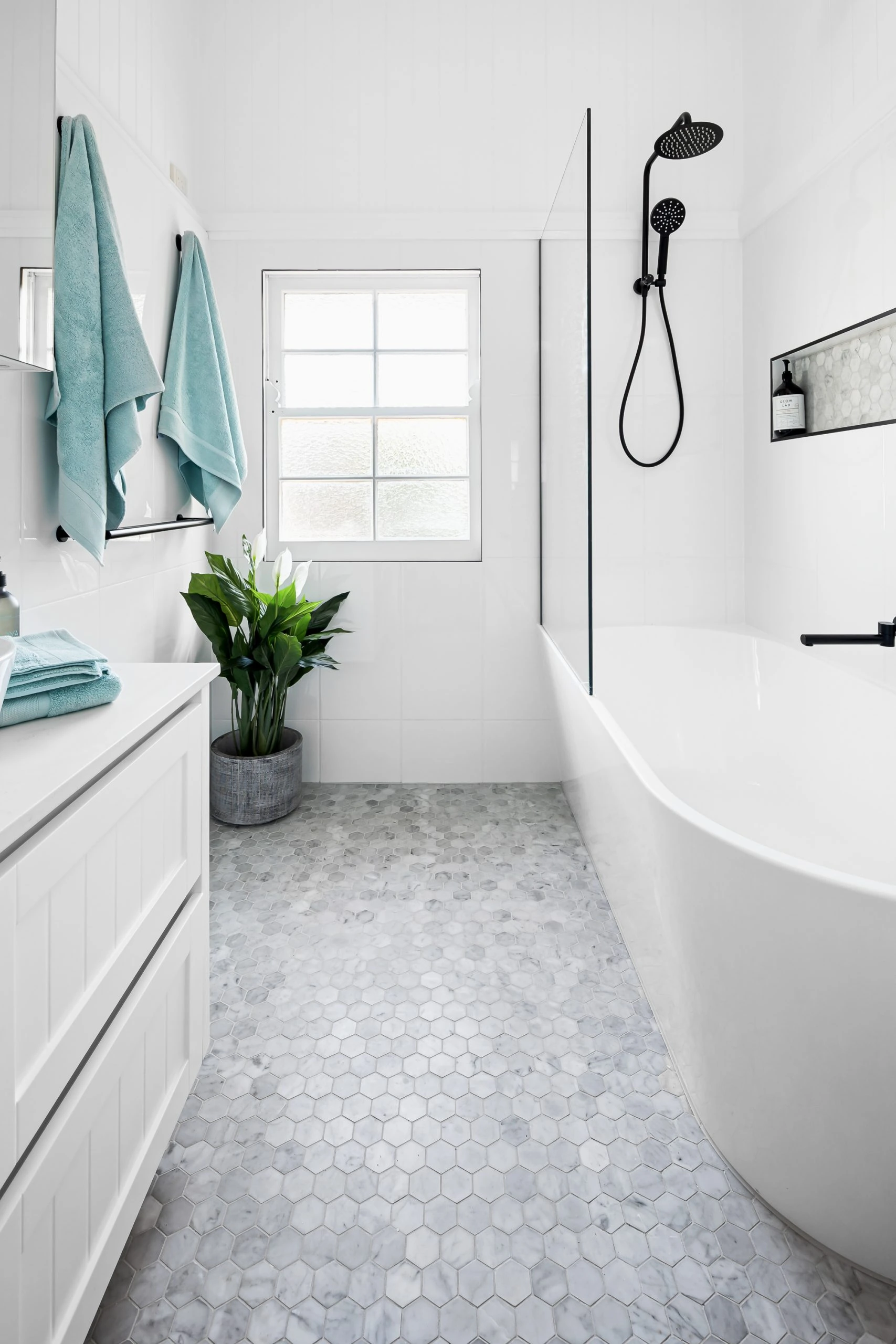White bathroom with black details and blue towels