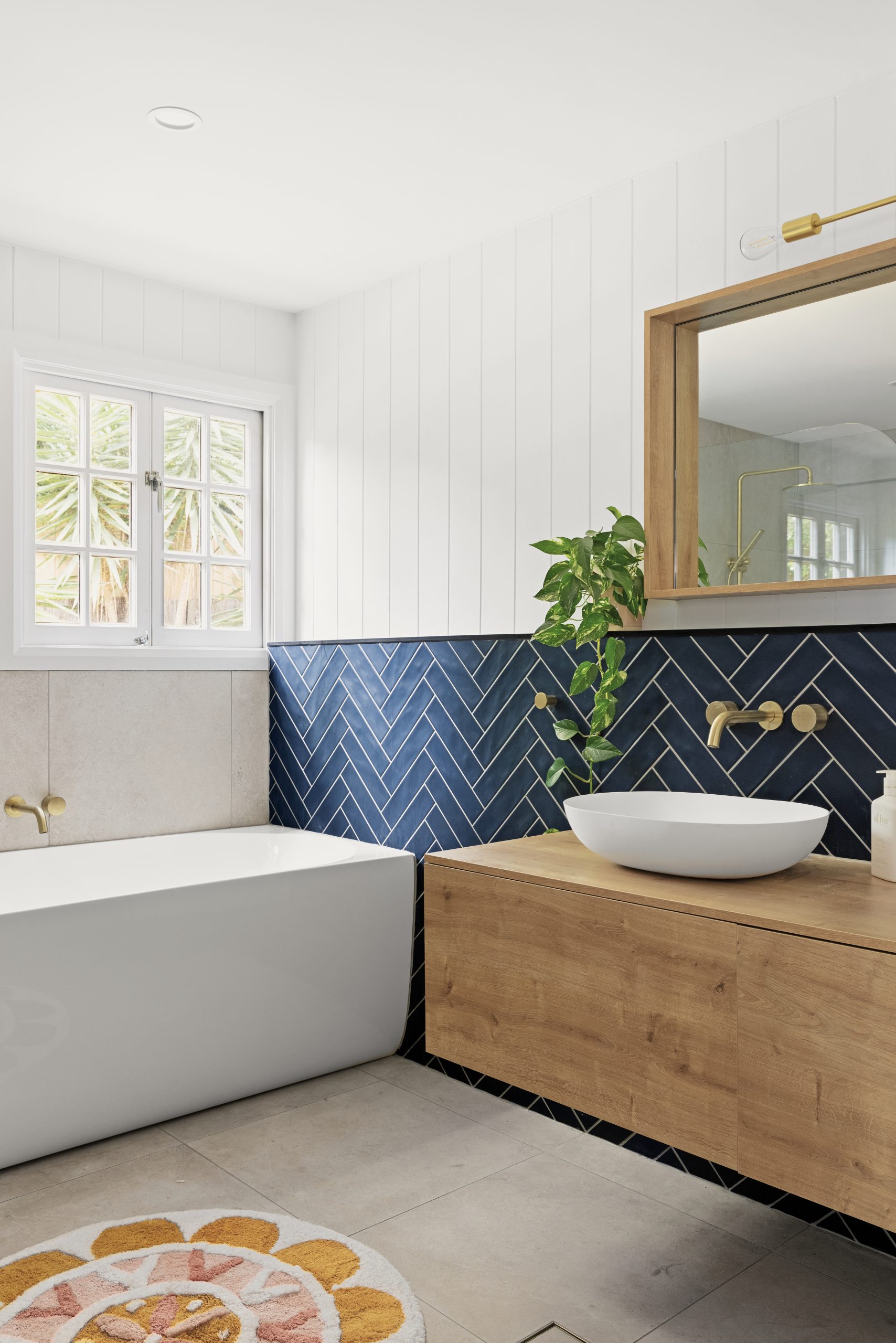 Blue herringbone bathroom tiles in a modern bathroom renovation after photo.