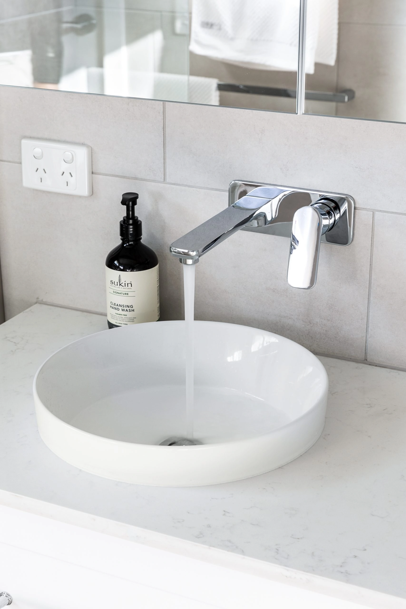 Chrome tap over a white bathroom sink