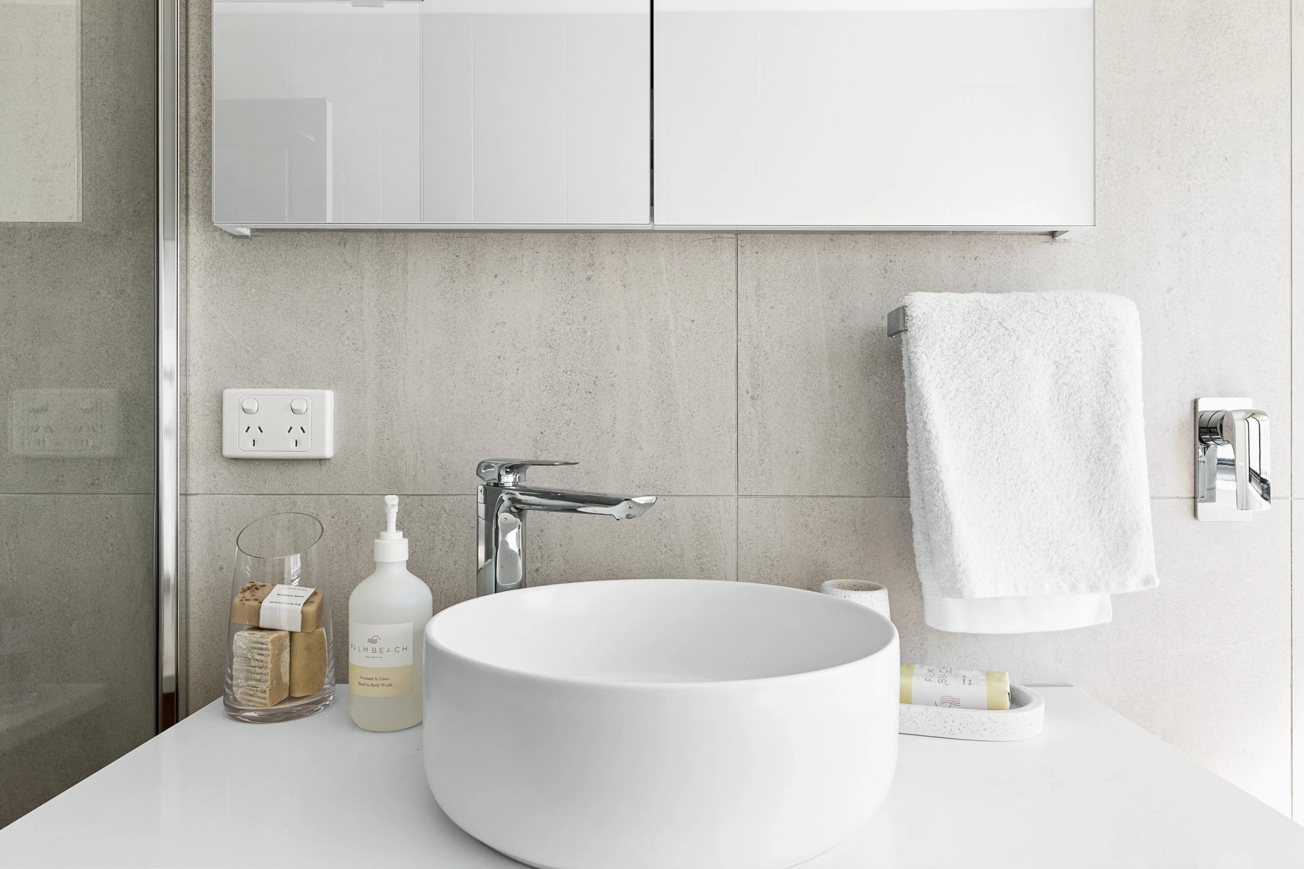 White sink with chrome tap in a modern, light bathroom