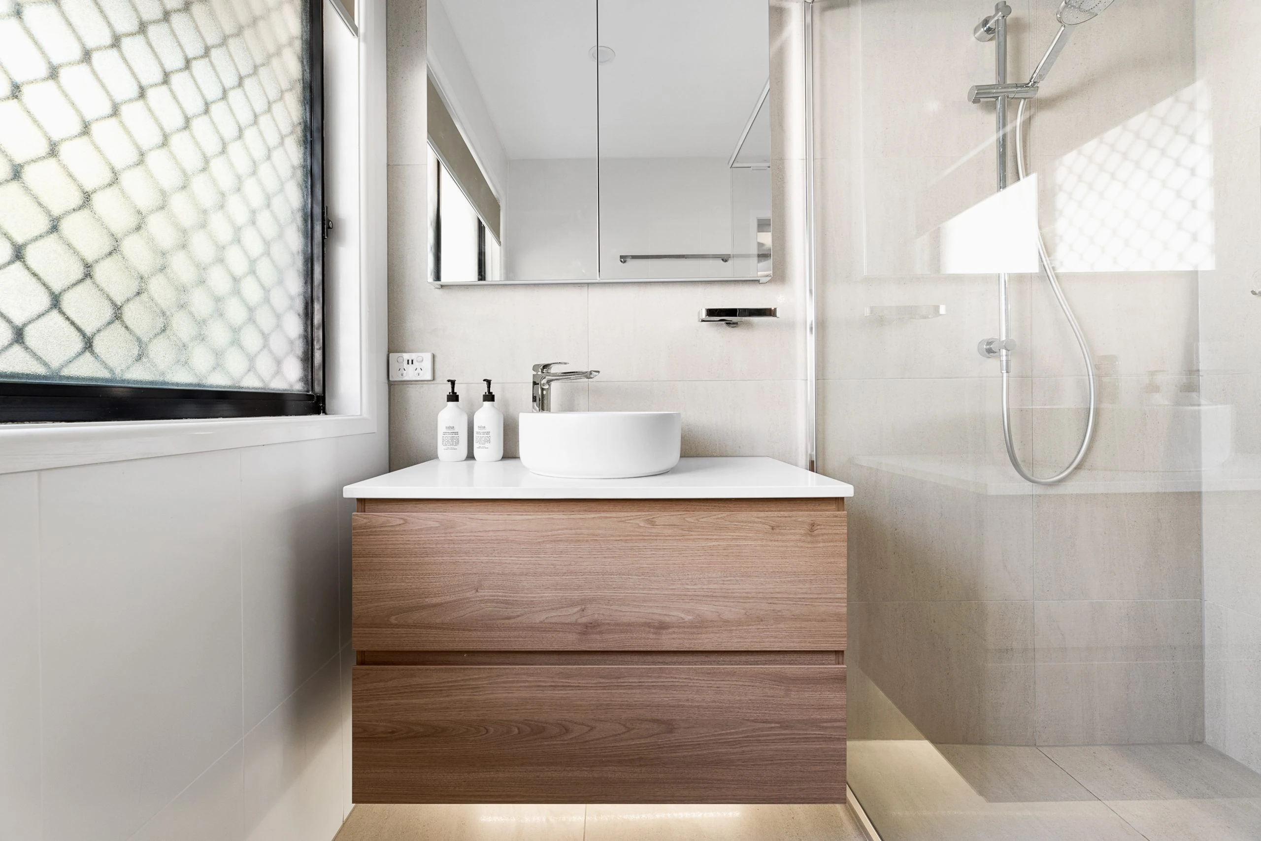 Wooden vanity unit in a light modern bathroom