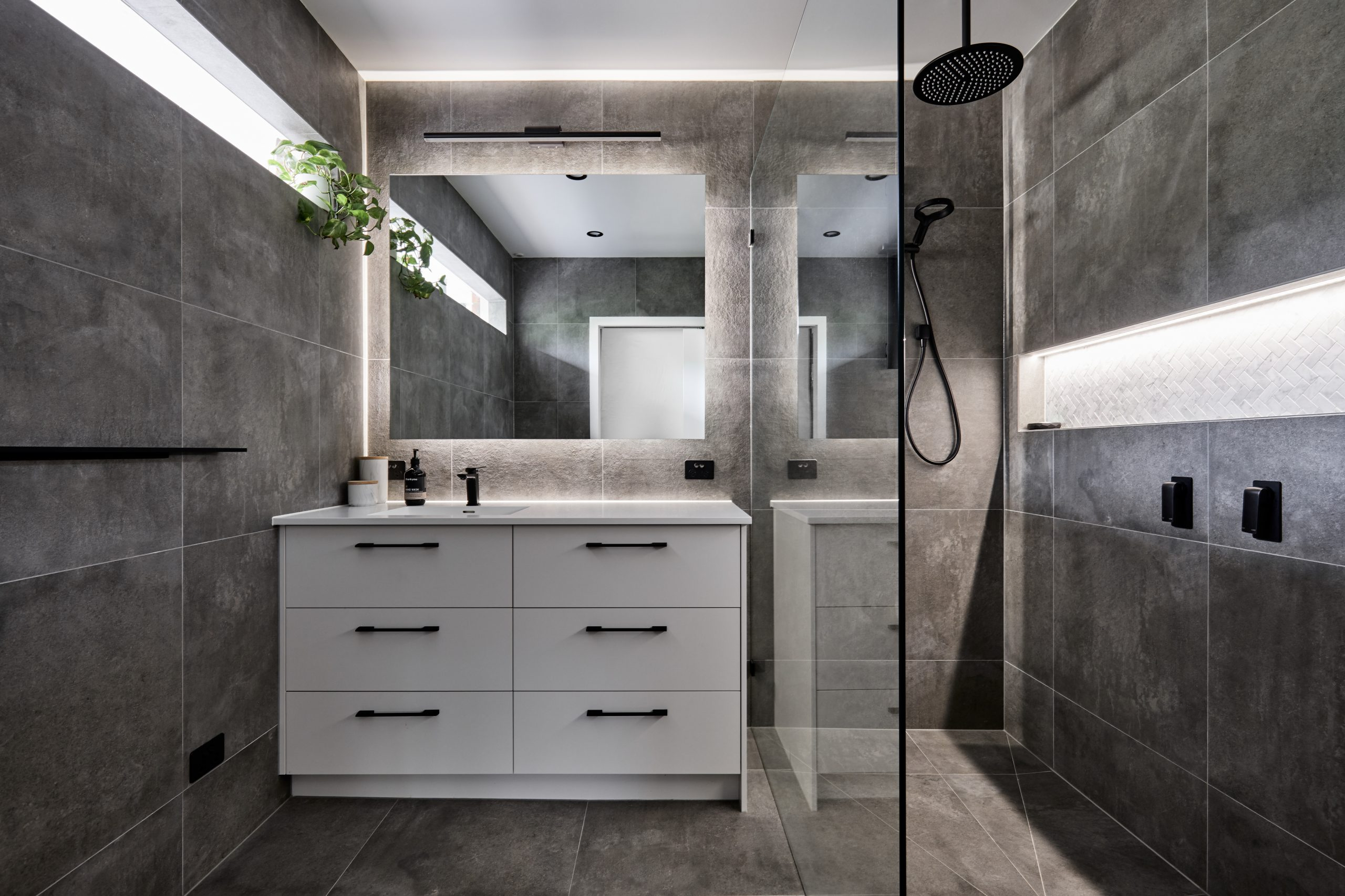 Grey bathroom with white unit and black details