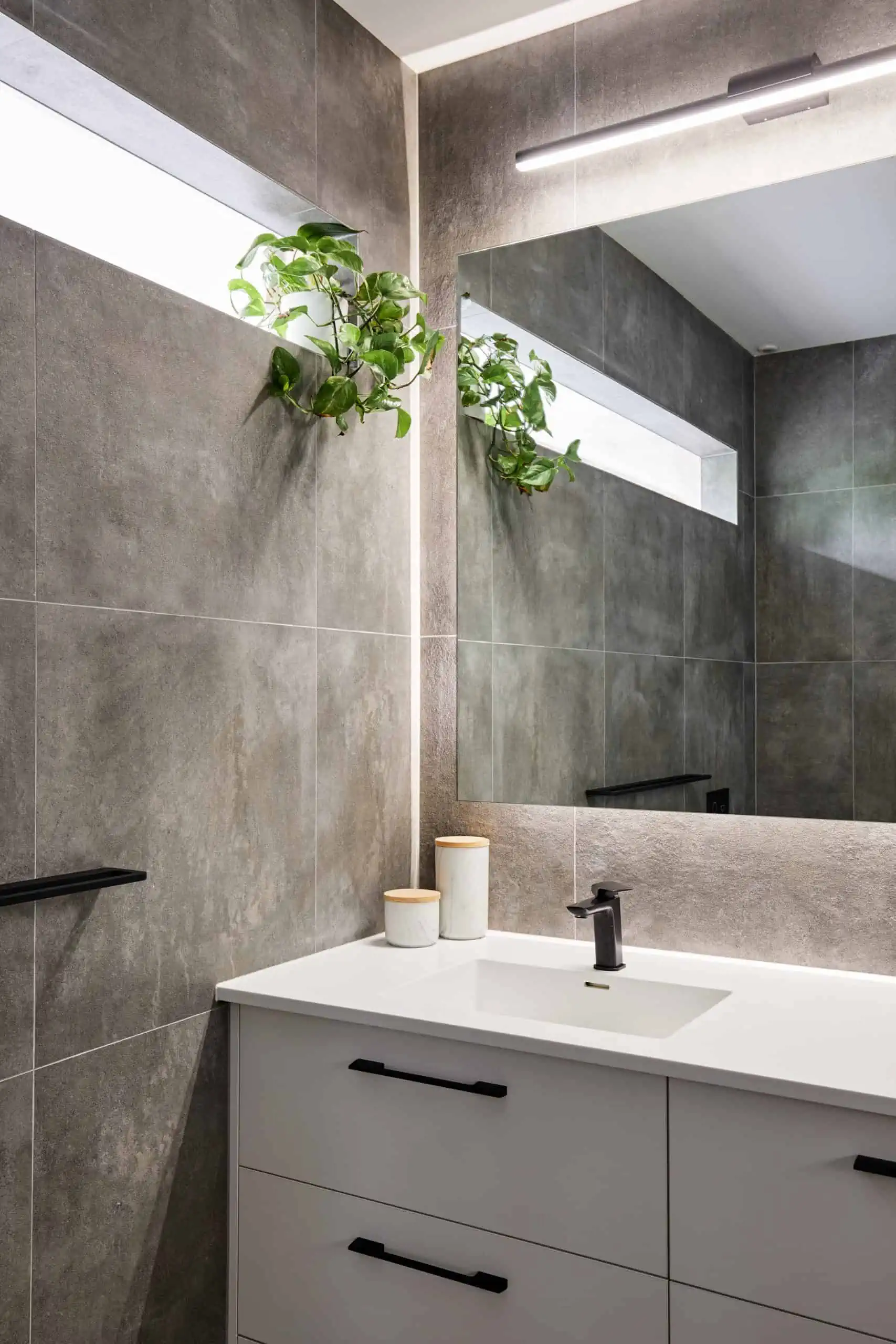 Natural stone wall tiles in a bright bathroom with a white unit
