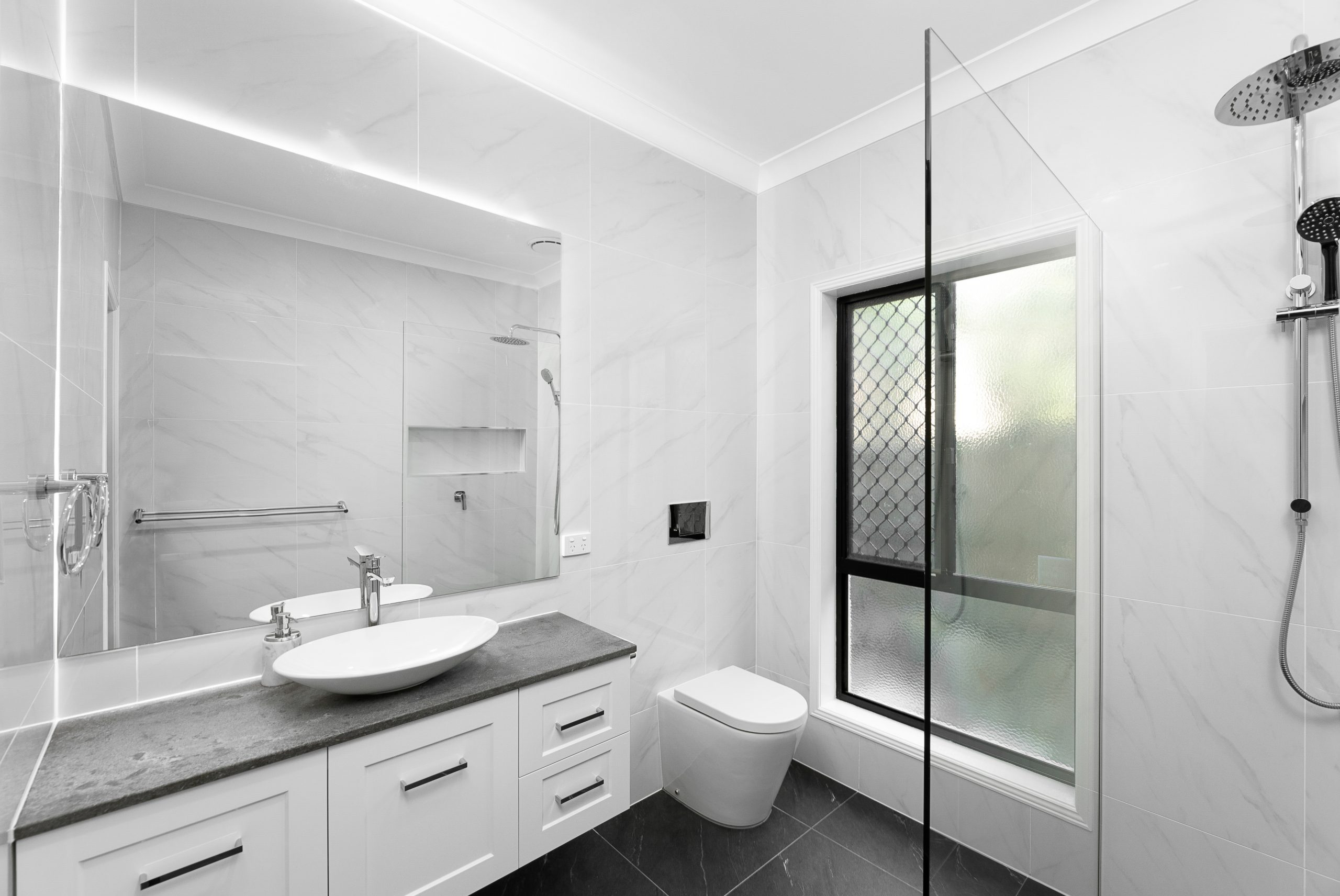 White modern bathroom with large mirror above the sink