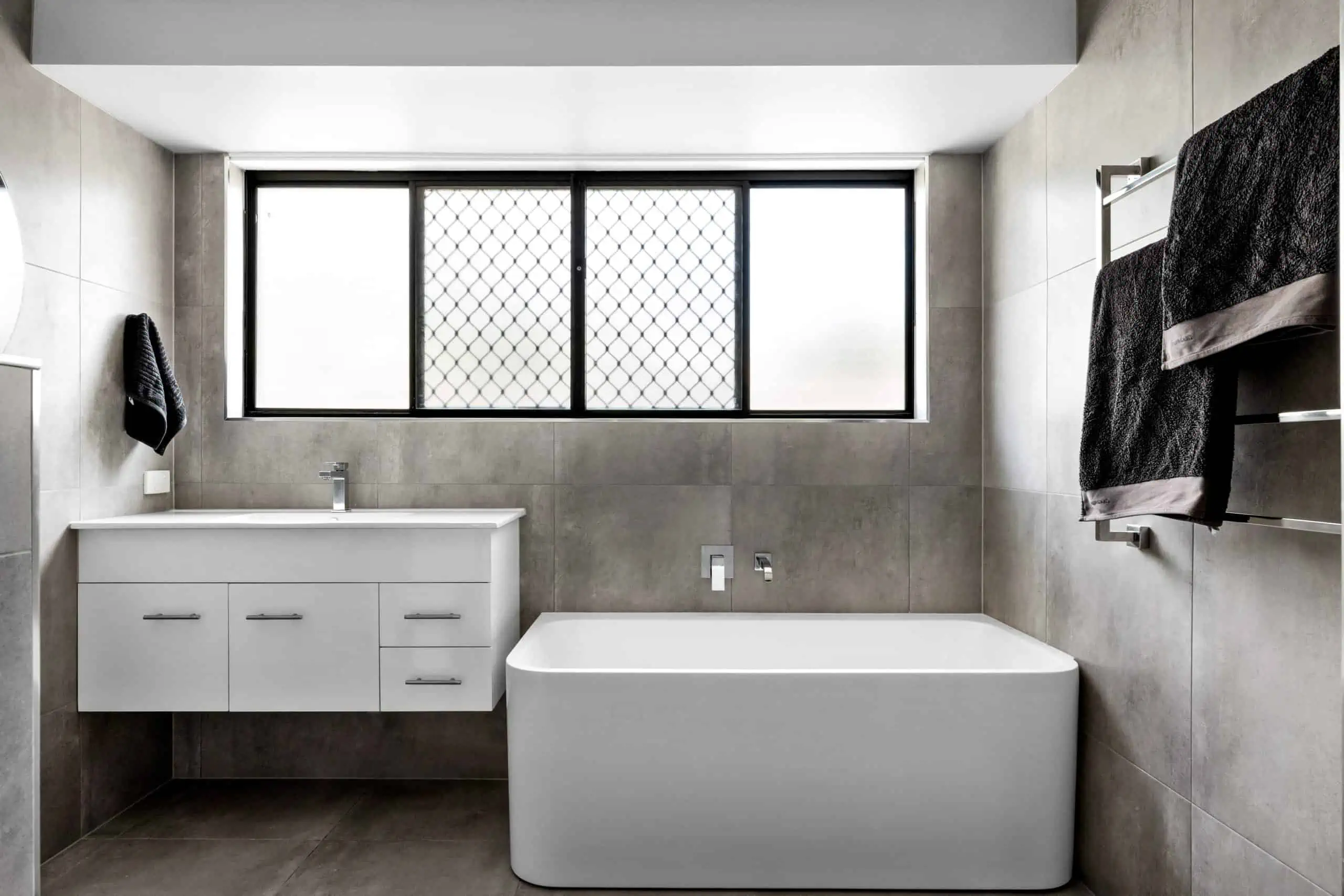 White vanity and sink and a modern grey bathroom