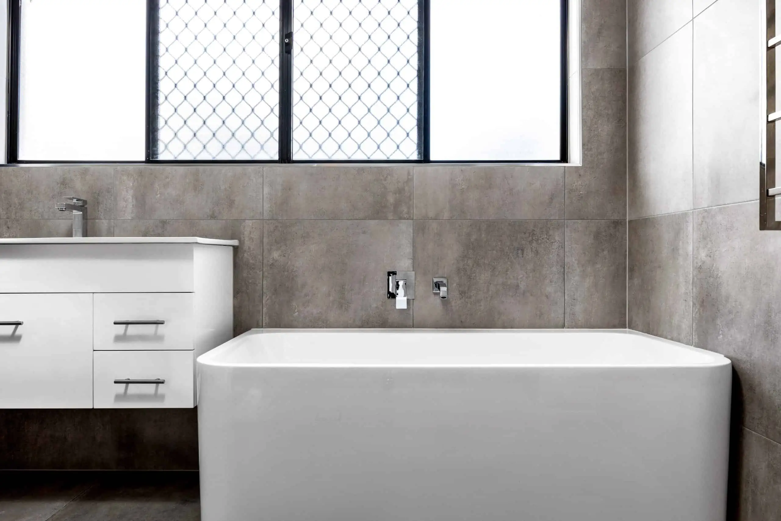 White vanity unit and bath in modern bathroom