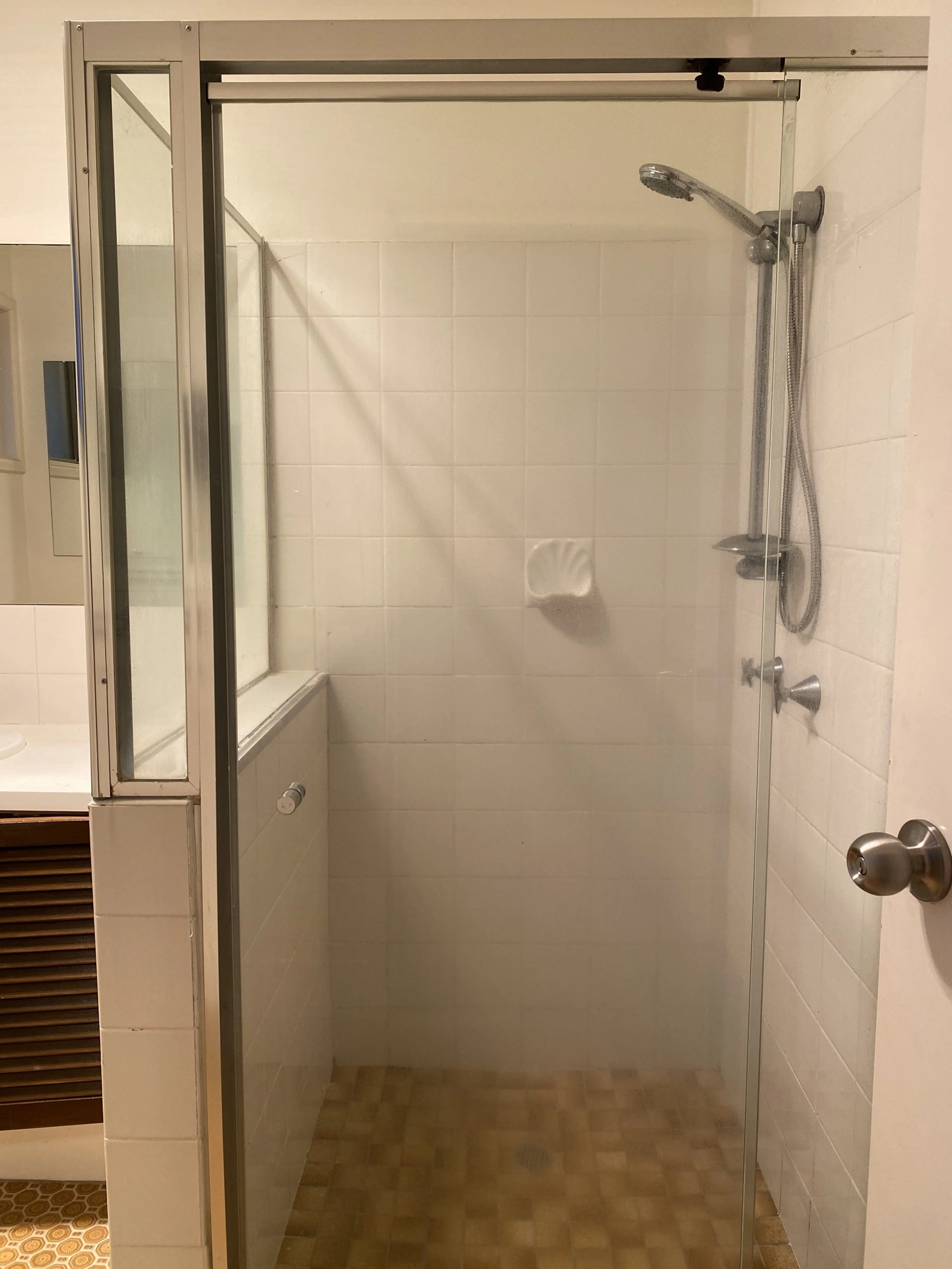 Before photograph of a shower area before a bathroom renovation